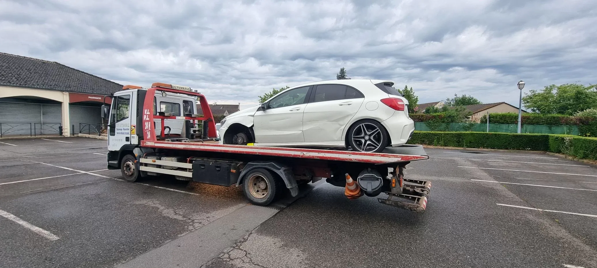 Camion dépanneuse remorquant une voiture blanche en Île-de-France